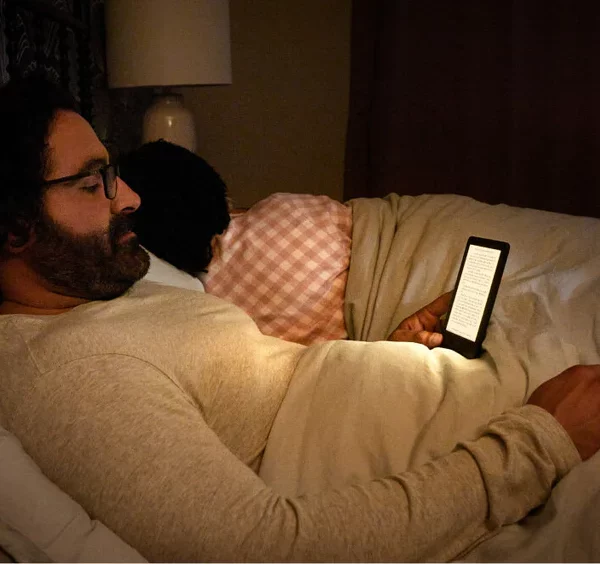 Senior czytający ebooka na Kobo Clara 2E w łóżku