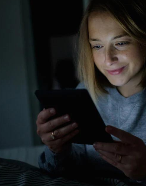 Kobieta czytająca e-booka na Kobo Nia w ciemności
