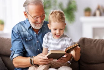 Dziadek z wnukiem czytają książkę.