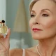 Piekna kobieta 60+ trzyma w dłoni perfumy, które uosabiają elegancję.