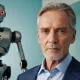 10 mitów na temat sztucznej inteligencji. Na zdjęciu mężczyzna 50+, a za nim w tle robot.