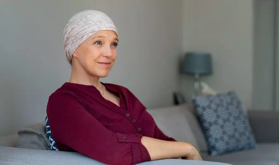 Czy emerytowi choremu na nowotwór złośliwy przysługuje z ZUS dodatek do emerytury? Na zdjęciu kobieta chora na raka.