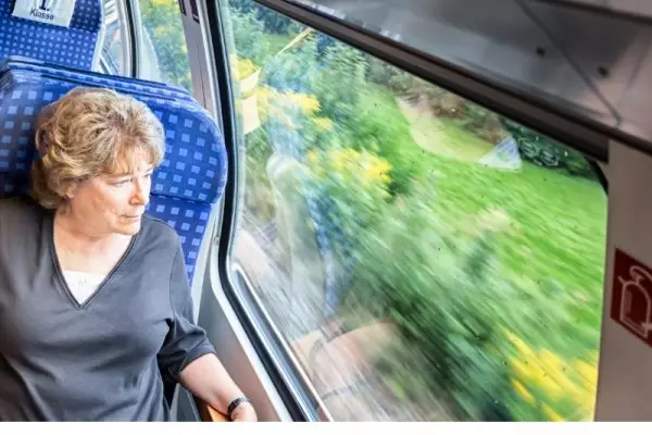 Bilet seniora PKP – jakie są zniżki i warunki dla emeryta? na zdjęciu kobieta w podróży.