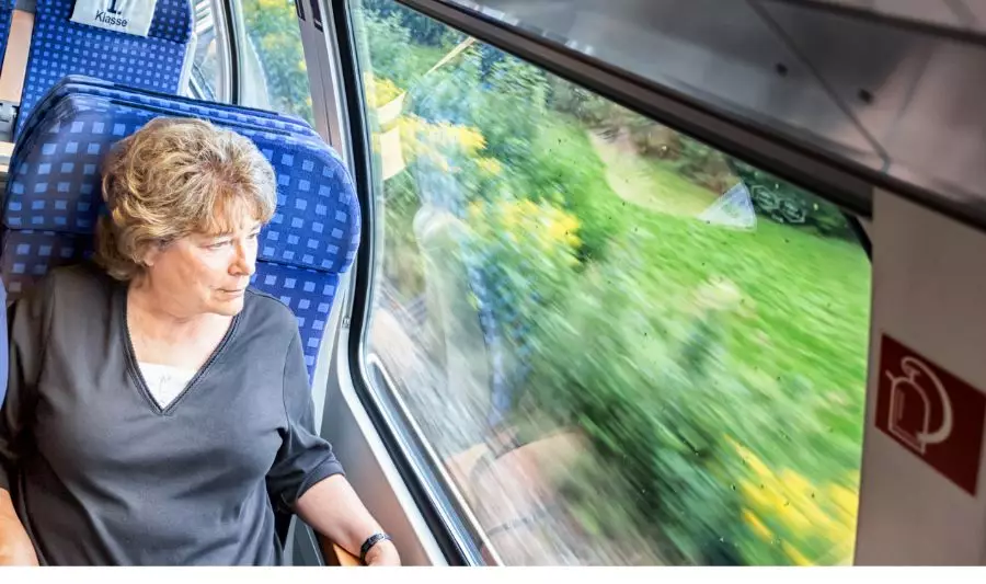 Bilet seniora PKP – jakie są zniżki i warunki dla emeryta? na zdjęciu kobieta w podróży.