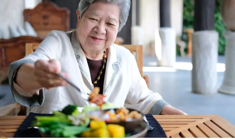 Kobieta spożywa danie, które zakłada dieta keto dla seniora.