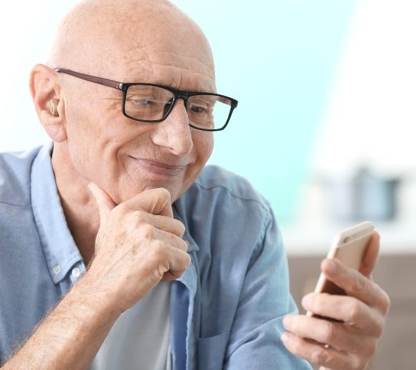 Newsletter – co to jest? Na zdjęciu senior czytający newsletter.