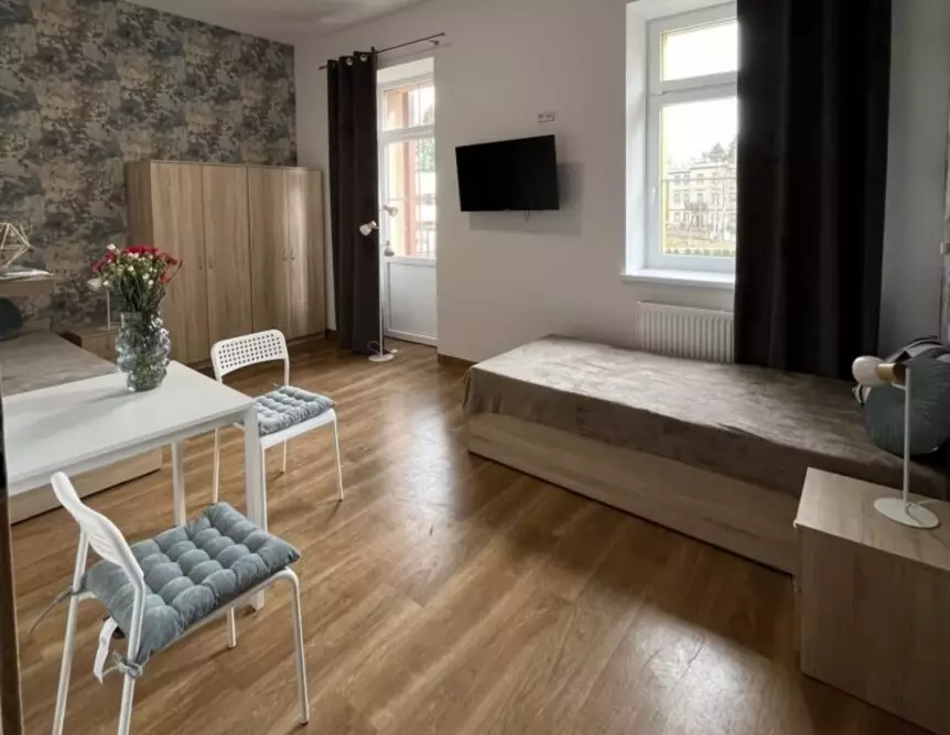 W pokojach mieszkańców Cieplickiej Rezydencji Seniorów w Jeleniej Górze znajdują się wygodne łóżka, telewizor, a także balkon