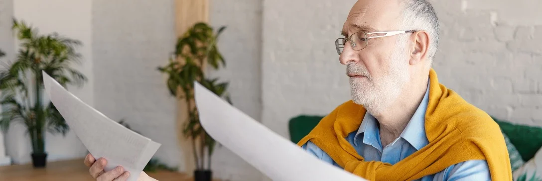 starszy mężczyzna przeglądający dokumenty