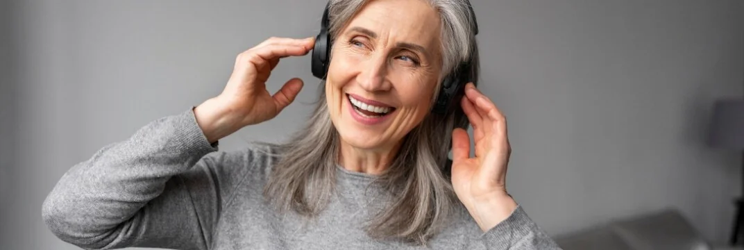 seniorka słuchająca audiobooka