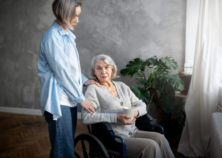 Opiekunka pomaga seniorce na wózku w domowych warunkach – opieka nad osobą starszą