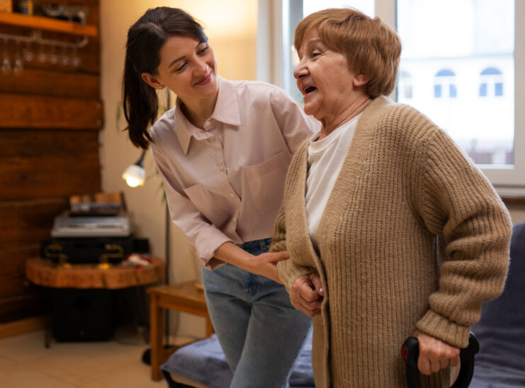 seniorka idzie, obok niej młodsza kobieta, która jej pomaga 