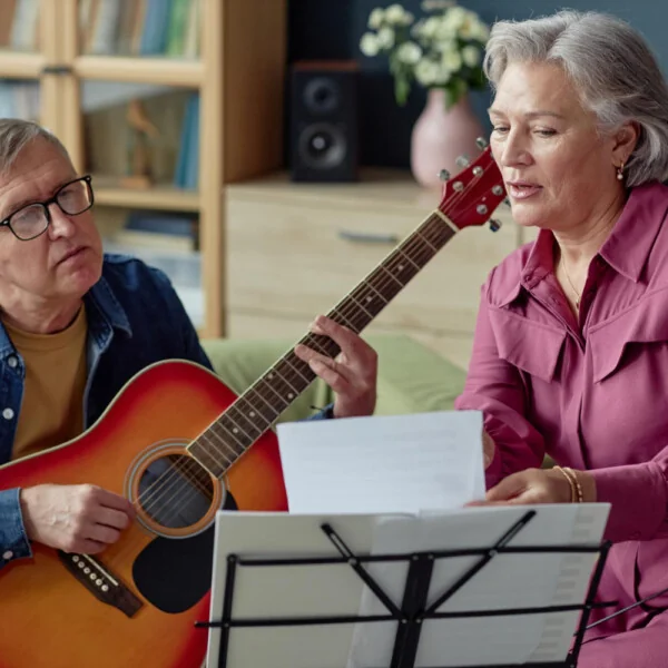 seniorzy uczą się gry na gitarze