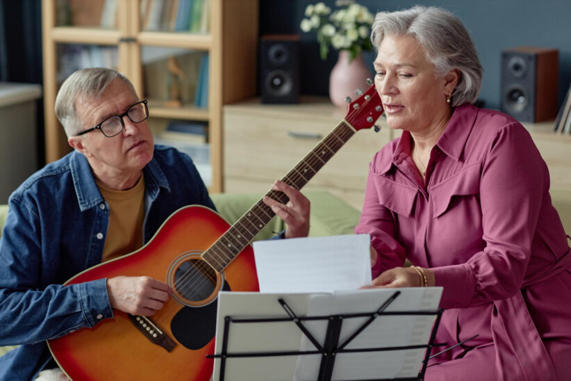 seniorzy uczą się gry na gitarze
