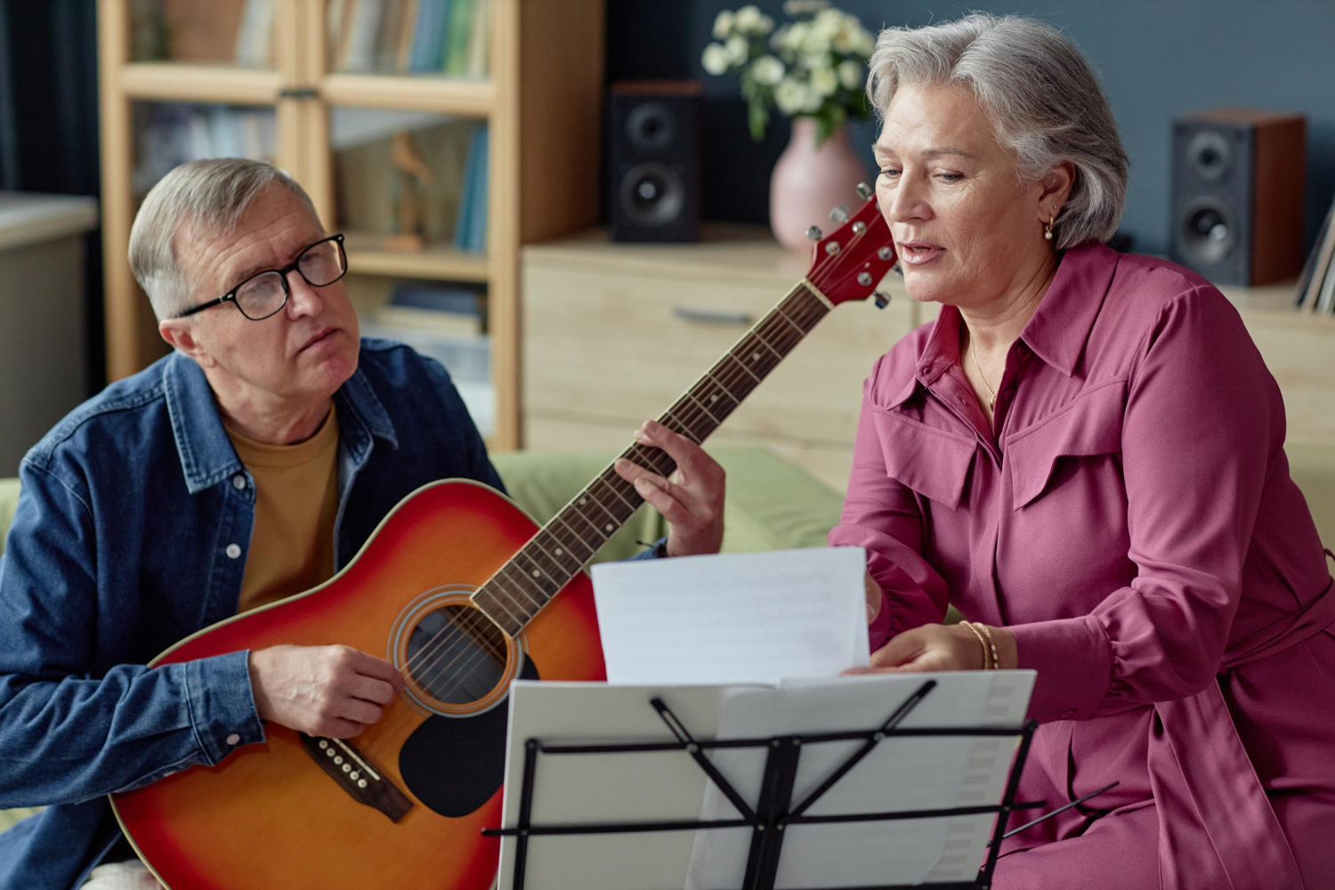 seniorzy uczą się gry na gitarze