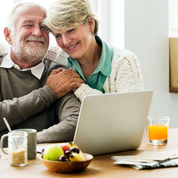 emeryci w domu przed laptopem