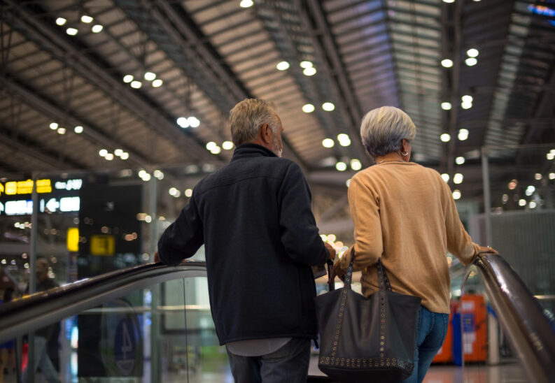 Seniorzy podróżujący po dworcu korzystający ze zniżek na bilety i przejazdy
