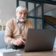 senior korzystający w salonie z laptopa