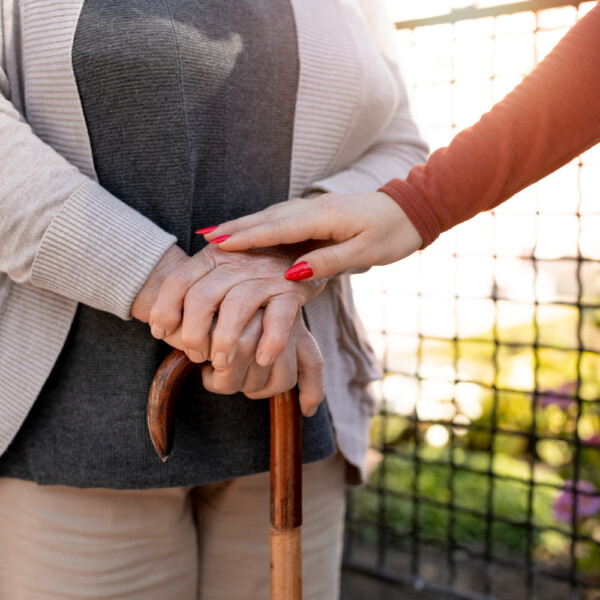Seniorka z laską i opiekunka – symbol opieki długoterminowej i wsparcia