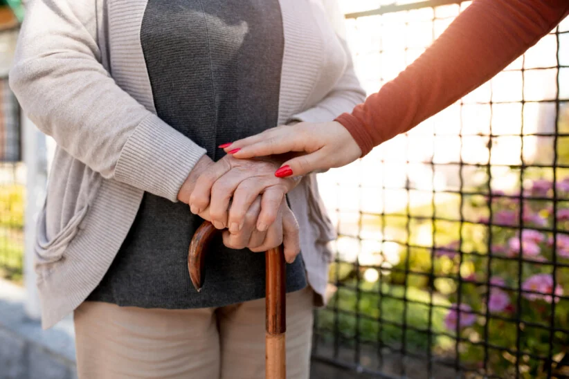 Seniorka z laską i opiekunka – symbol opieki długoterminowej i wsparcia
