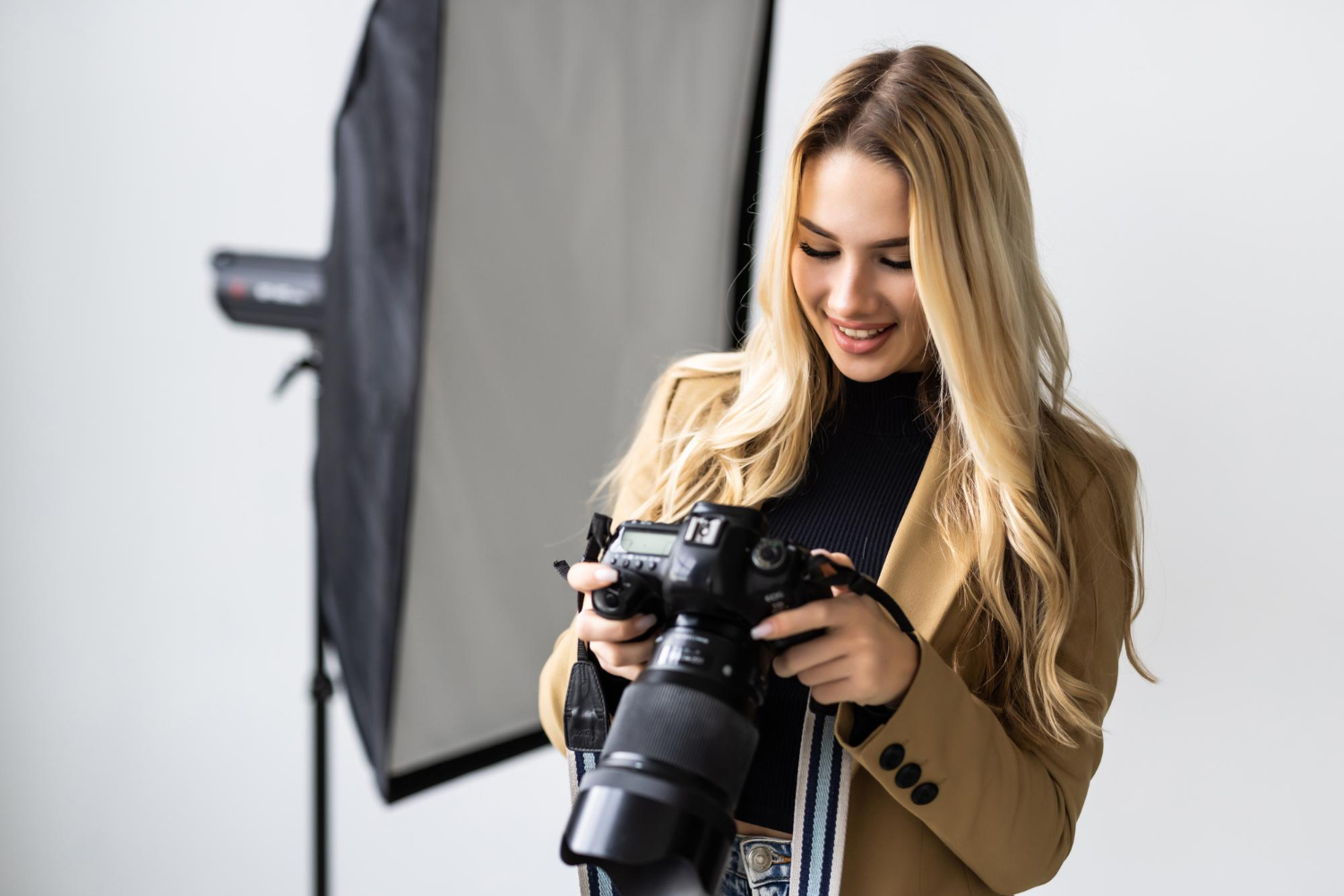 Kobieta fotograf przegląda zdjęcia w aparacie podczas sesji w studiu