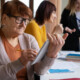 Seniorka wypełnia dokumenty podczas wizyty w urzędzie