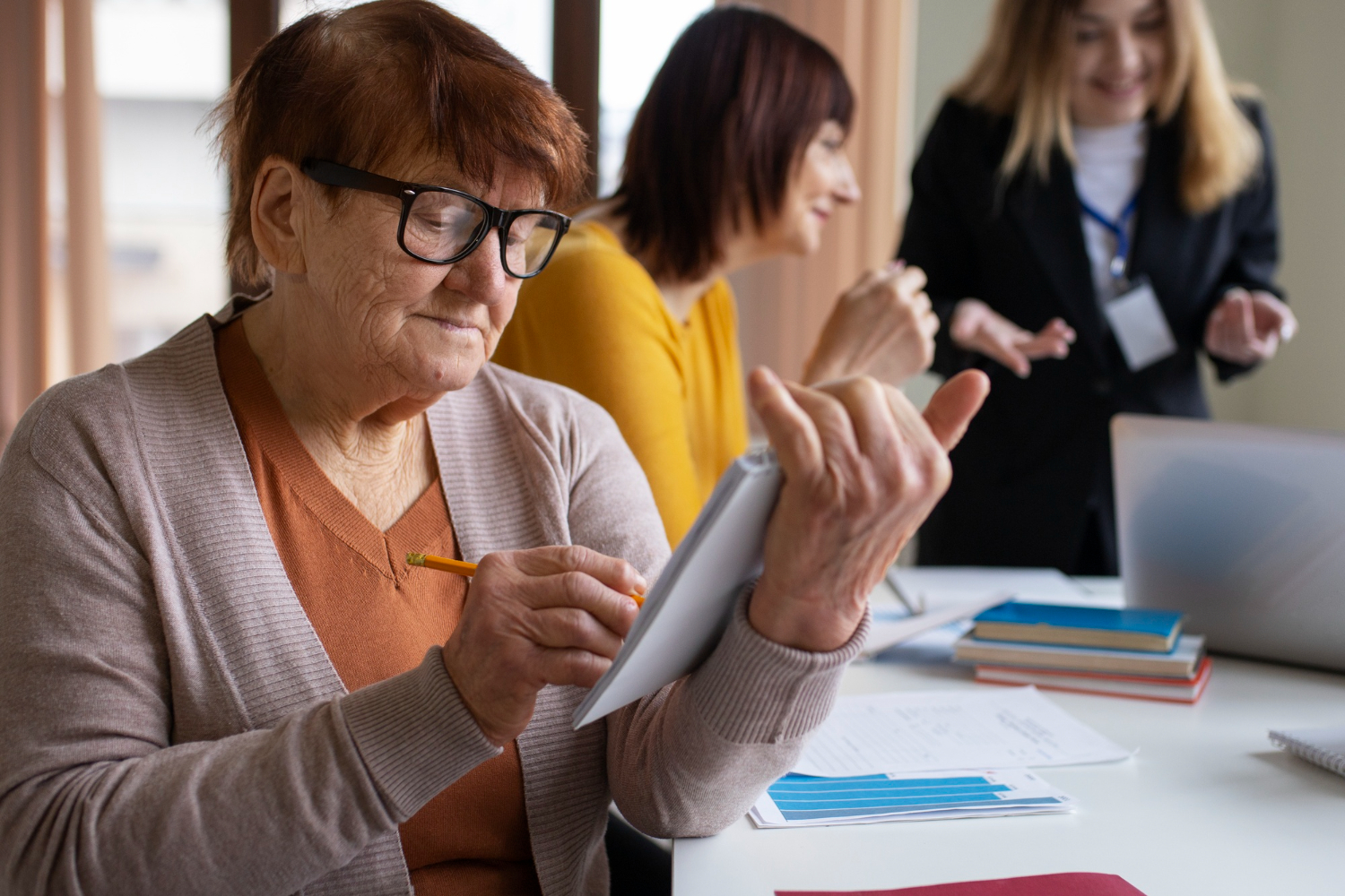 Seniorka wypełnia dokumenty podczas wizyty w urzędzie