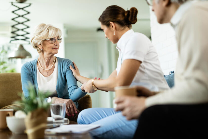 Seniorka rozmawiająca z opiekunką podczas spotkania w domu opieki lub placówce wsparcia