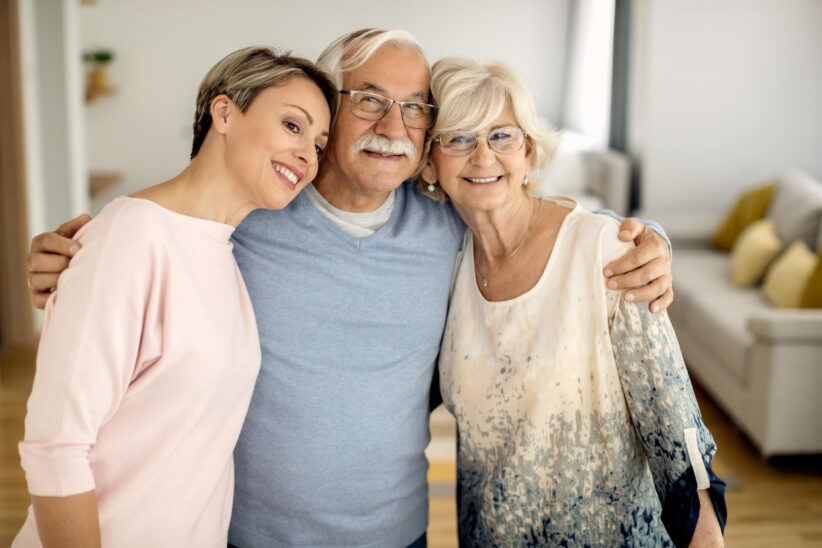 Seniorka i senior z córką w rodzinnym uścisku