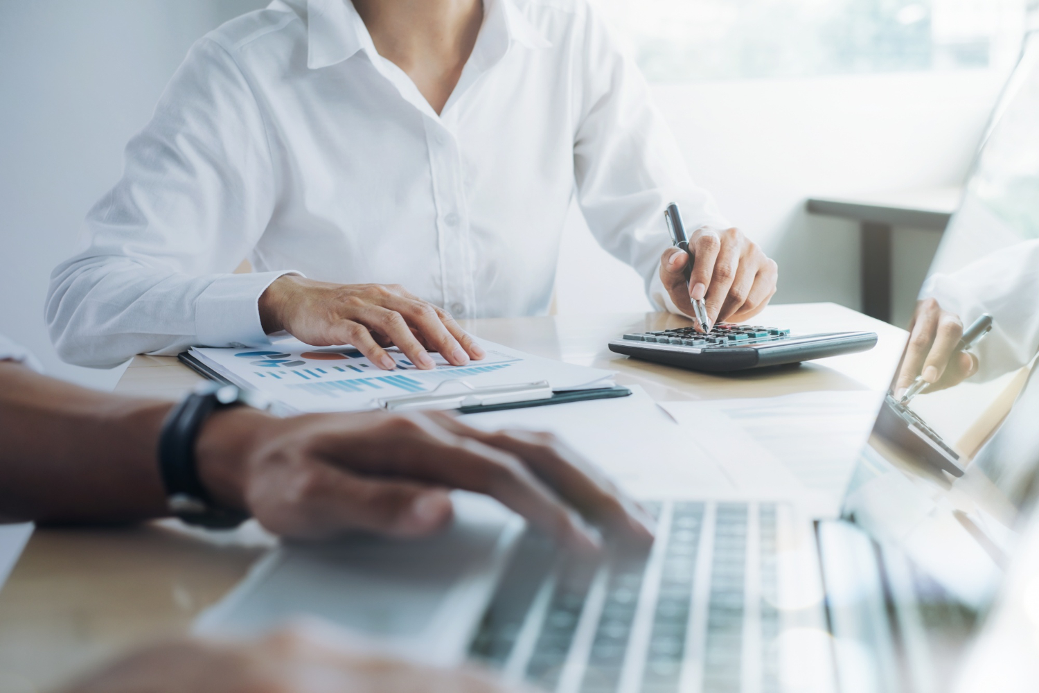 Spotkanie z doradcą finansowym podczas omawiania dokumentów i obliczeń przy laptopie