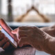 Smartfon w rękach seniora, czytającego SMS z fałszywym linkiem - oszustwo metodą na ZUS